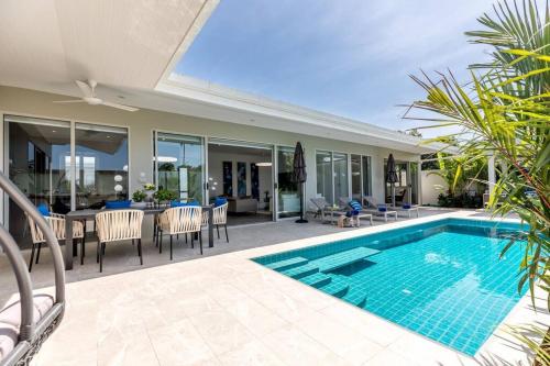 a villa with a swimming pool and a dining area at Big & Stylish 5 Bed 4 Bath Private Garden Pool Villa at Thongson Bay Beach in Koh Samui 