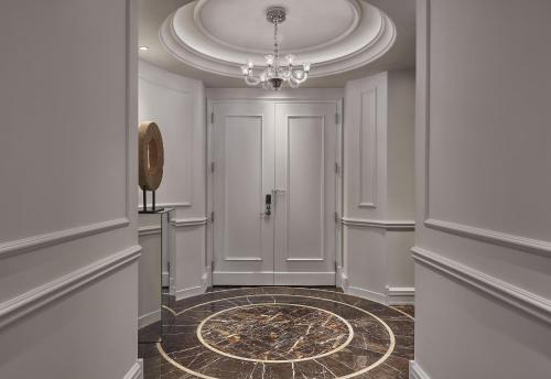 a hallway with a door and a chandelier at Rosewood Washington DC in Washington