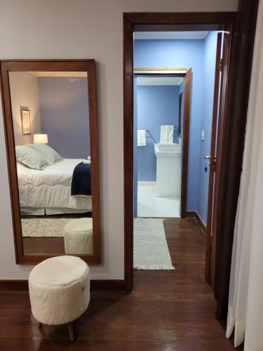 1 dormitorio con espejo, 1 cama y baño en Espaço Tramonto, en Itaipava