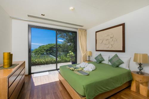 a bedroom with a green bed and a large window at The heights Penthouse Ocean view A11 Near Kata Beach in Kata Beach