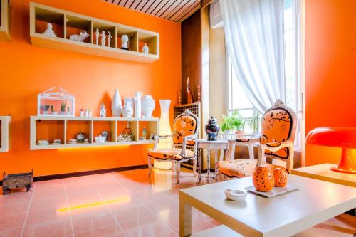 a living room with orange walls and a table and chairs at Albergo Villa Gaia in Chianciano Terme