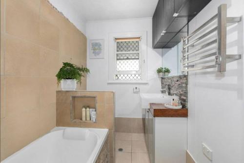 un baño con bañera y lavabo en Beach Pad close to Airport and Iconic Kirra Beach, en Gold Coast