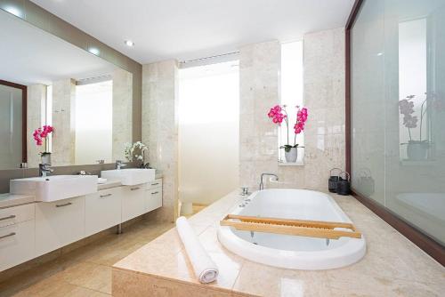 un bagno con una grande vasca e due lavandini di Luxury Resort Studio with Pool - Footsteps to Beach a Casuarina