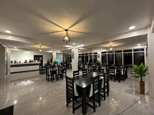 un restaurante con mesas y sillas y un bar en Fight Club Philippines Fitness Resort en Bacungan