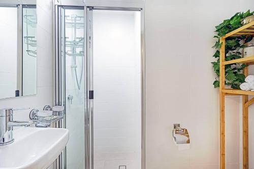 a bathroom with a glass shower and a sink at 'Buzzing Surfers' Vibrant Indoor-outdoor Lifestyle in Gold Coast