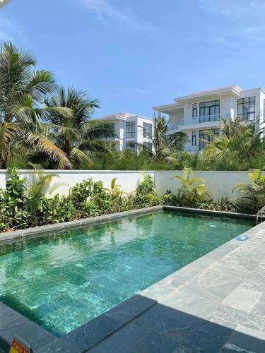 a swimming pool in front of a building at Sea Villa - FLC Sam Son in Sầm Sơn