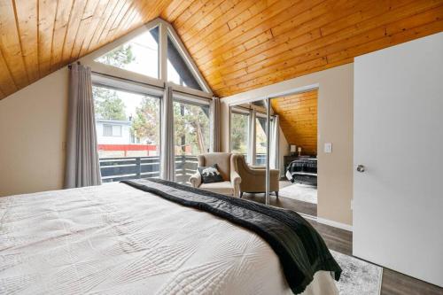 - une chambre avec un grand lit et une grande fenêtre dans l'établissement The Heartfelt Cabin: Best Views, Large Backyard!, à Big Bear City