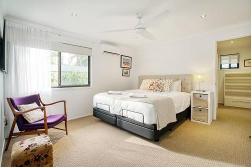 una camera da letto con un letto, una sedia e una finestra di Sunny Days Poolside at an Entertainer's Oasis a Gold Coast