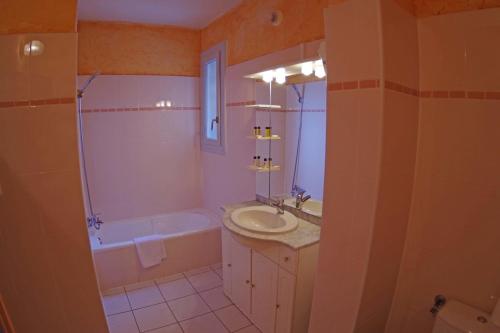 a bathroom with a sink and a tub and a toilet at Le Méditerranée in Porto Ota