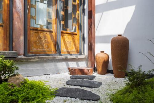 two vases sitting in front of a door next to a doorway at Honglu Garden Hotel Bell and Drum Tower Huimin Street Store & 2 bottles of beer for free in Xi'an