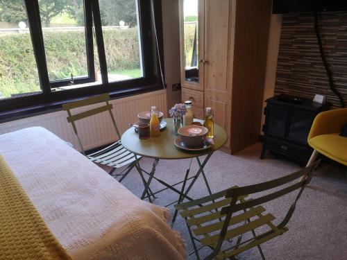a bedroom with a table with food and drinks on it at Y Cuddfan Gower in Swansea