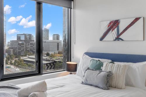 a bedroom with a bed and a large window at Resort Style Living Yarra Wharf in Melbourne