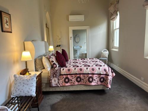 a bedroom with a bed and a table and a mirror at Convent at Koroit in Koroit