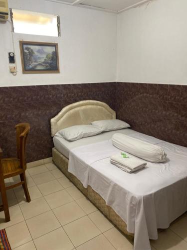 um quarto com uma cama com toalhas em Hotel Wisma Hasanah em Srondolwetan