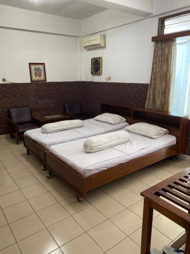um quarto com 2 camas e um piano em Hotel Wisma Hasanah em Srondolwetan