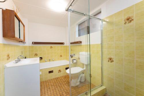 a bathroom with a toilet and a glass shower at Oceancrest 4 in Forster