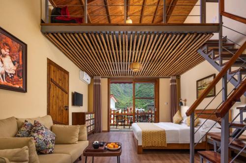 un soggiorno con letto e scala di Yangshuo Coco Garden Hotel a Yangshuo