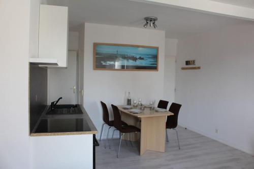 une cuisine avec une table et des chaises dans une pièce dans l'établissement Appartement centre de Crozon - 5 min des plages, à Crozon