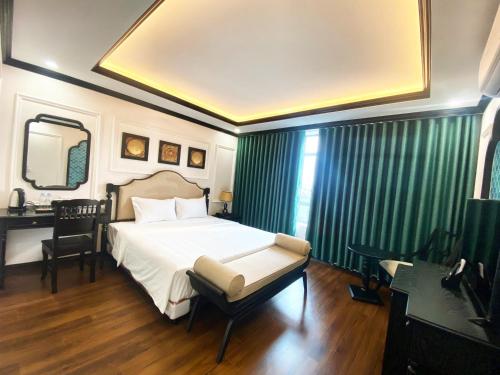 a bedroom with a bed and a desk and a mirror at Moma Paris Hotel Ninh Bình in Ninh Binh