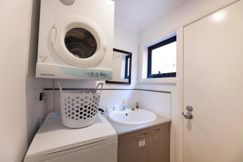 a small bathroom with a sink and a washing machine at Gwydir Court 1 in Forster