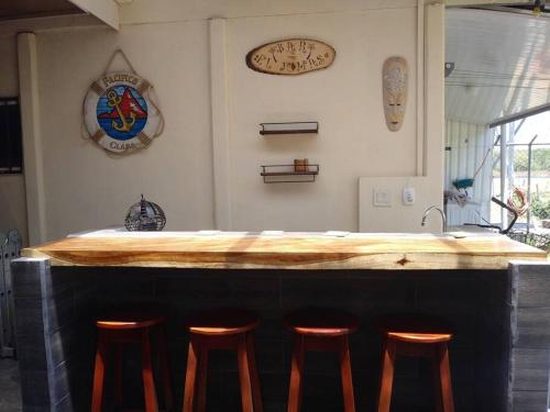 a kitchen with a bar with stools around it at Estrella de Mar Home in Jobos