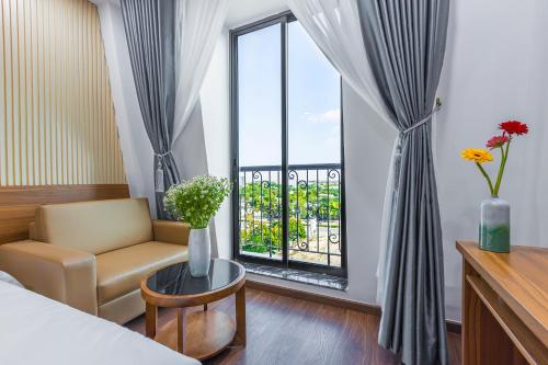 um quarto com uma cama, uma cadeira e uma janela em Tokyo Hotel Phan Rang em Thôn Mỹ Phước