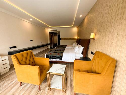 a hotel room with a bed and two chairs at Lake View Resort in Pokhara