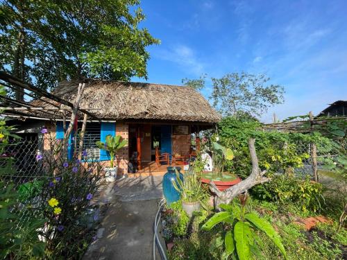 a small house with a thatched roof at Vong Nguyet Homestay - Entire Bungalow 36m2 in Tây Ninh