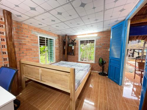 1 dormitorio con cama y pared de ladrillo en Vong Nguyet Homestay - Entire Bungalow 36m2, en Tây Ninh