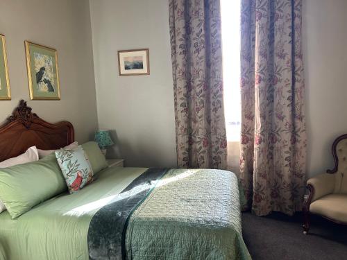a bedroom with a bed and a window with curtains at Convent at Koroit in Koroit