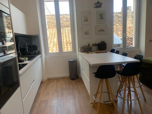 a kitchen with a counter and stools in a room at Appartement Design sur Vauban in Marseille