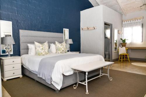a bedroom with a large bed with a blue wall at Gowan Valley Guest Farm in Balgowan
