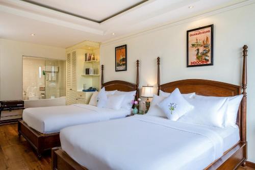 two beds in a hotel room with white pillows at Alagon City Hotel & Spa in Ho Chi Minh City