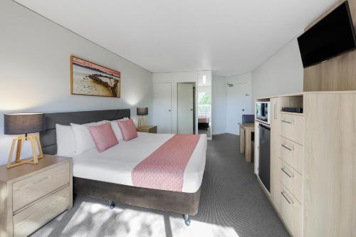 a bedroom with a large bed and a television at Club Wyndham Coffs Harbour Terraces in Coffs Harbour