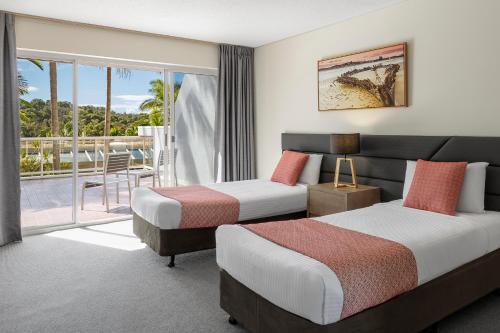 Habitación de hotel con 2 camas y balcón en Club Wyndham Coffs Harbour Terraces, en Coffs Harbour