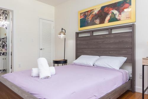 a bedroom with a large bed with white sheets at Las Olas Studio - 5 minutes from Las Olas Beach in Fort Lauderdale