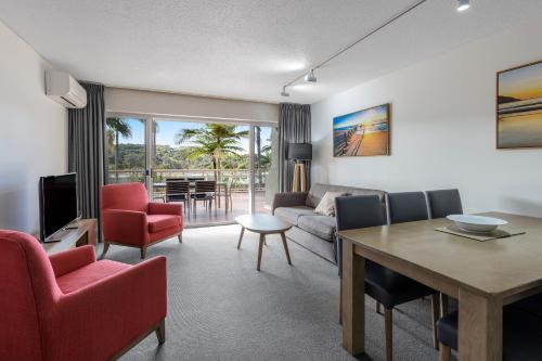 a living room with a couch and a table and chairs at Club Wyndham Coffs Harbour Terraces in Coffs Harbour