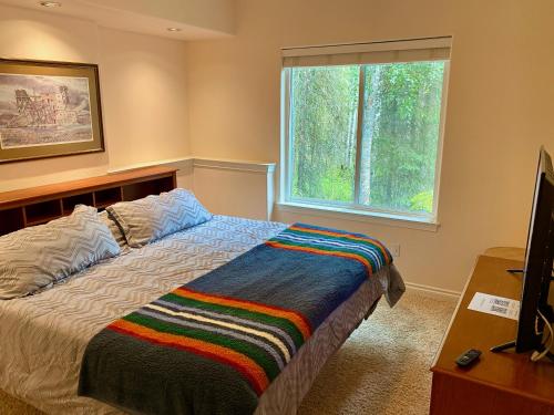 a bedroom with a large bed and a window at Guest Suite with Hot Tub - Edge of the Wild in Eagle River