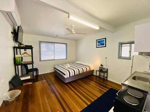 Schlafzimmer mit einem Bett und Holzboden in der Unterkunft Koala Lodge Studio 1 in Iluka