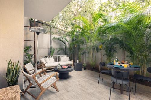 um pátio com um sofá, mesas e plantas em Classy 1 BR Apt w Private Balcony By Sea N' Rent em Tel Aviv
