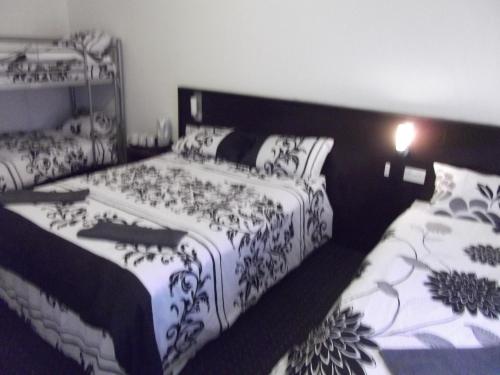 two beds sitting next to each other in a room at The Woodfield Hotel , Indoor Heated swimming pool, Spacious lounge and Bar in Blackpool