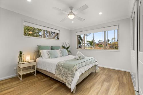 a white bedroom with a bed and a window at Berry Haven by Experience Jervis Bay in Vincentia