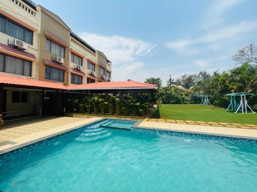 a swimming pool in front of a building at Mountview Resort in Lonavala