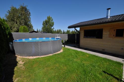 a swimming pool in a yard next to a house at Mieszkania Sowiogórskie u podnóża Gór Sowich in Pieszyce