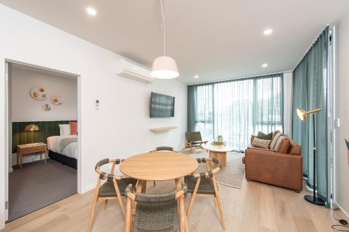 een woonkamer met een tafel en een slaapkamer bij Grow at Goodwood in Adelaide