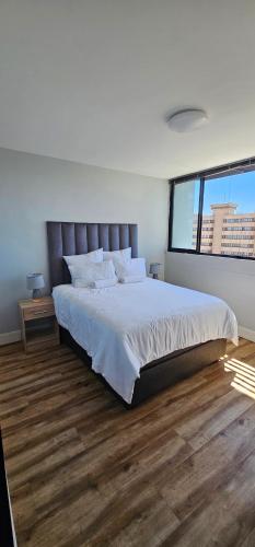 a bedroom with a large bed and a large window at Cozy Retreat in Windhoek in Windhoek