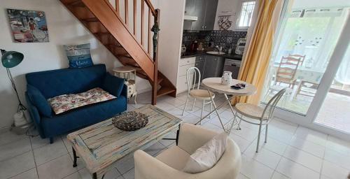 ein Wohnzimmer mit einem blauen Sofa und einem Tisch in der Unterkunft La maison coquillage in Le Barcarès
