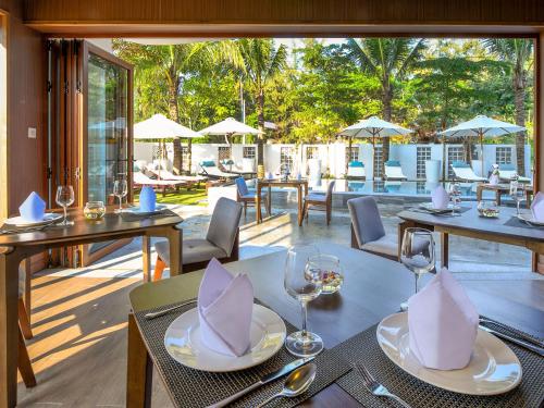 restauracja ze stołami i krzesłami oraz patio w obiekcie Hoi An Ocean Front Hotel w Hoi An