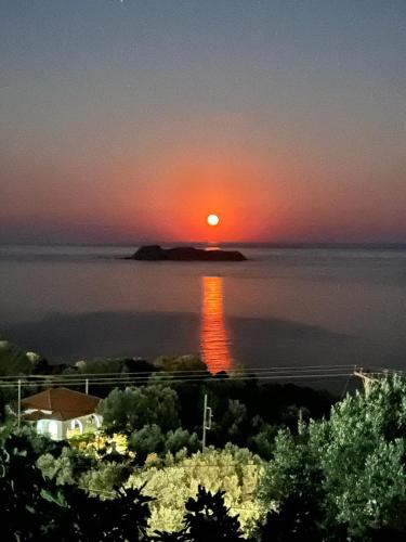 a sunset over a body of water with a house at Seagulls - Within walking distance from sea! in Petriaí