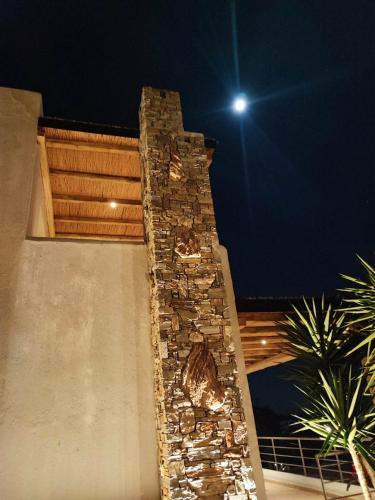 a stone pillar on the side of a building at night at Seagulls - Within walking distance from sea! in Petriaí